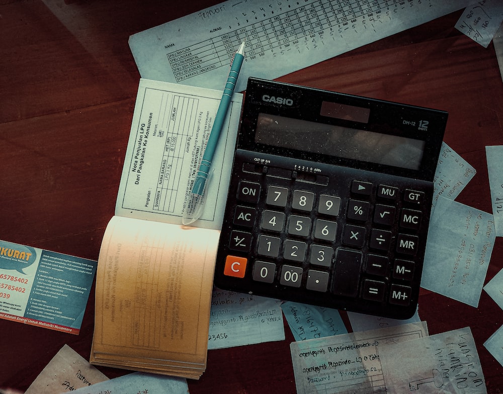 Plumbing invoice, calculator, and pen on a desk – essential tools for plumbers to manage billing and invoicing efficiently.