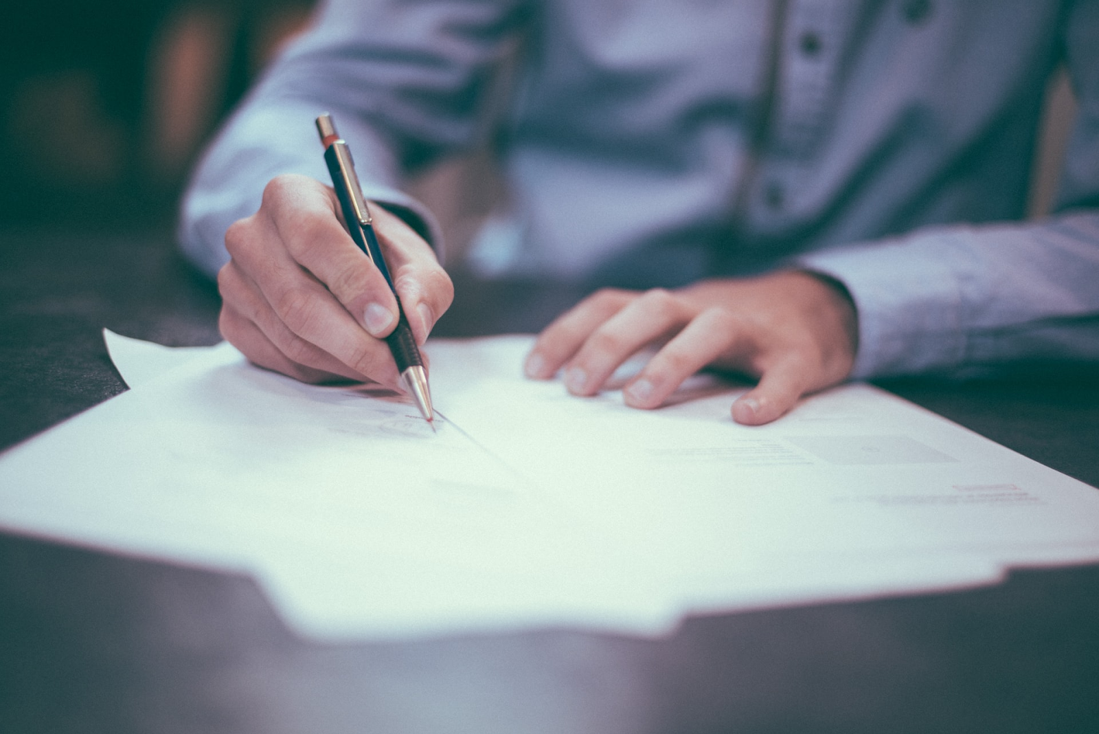 Business professional signing a document, representing the approval process of a quote or invoice in financial transactions.