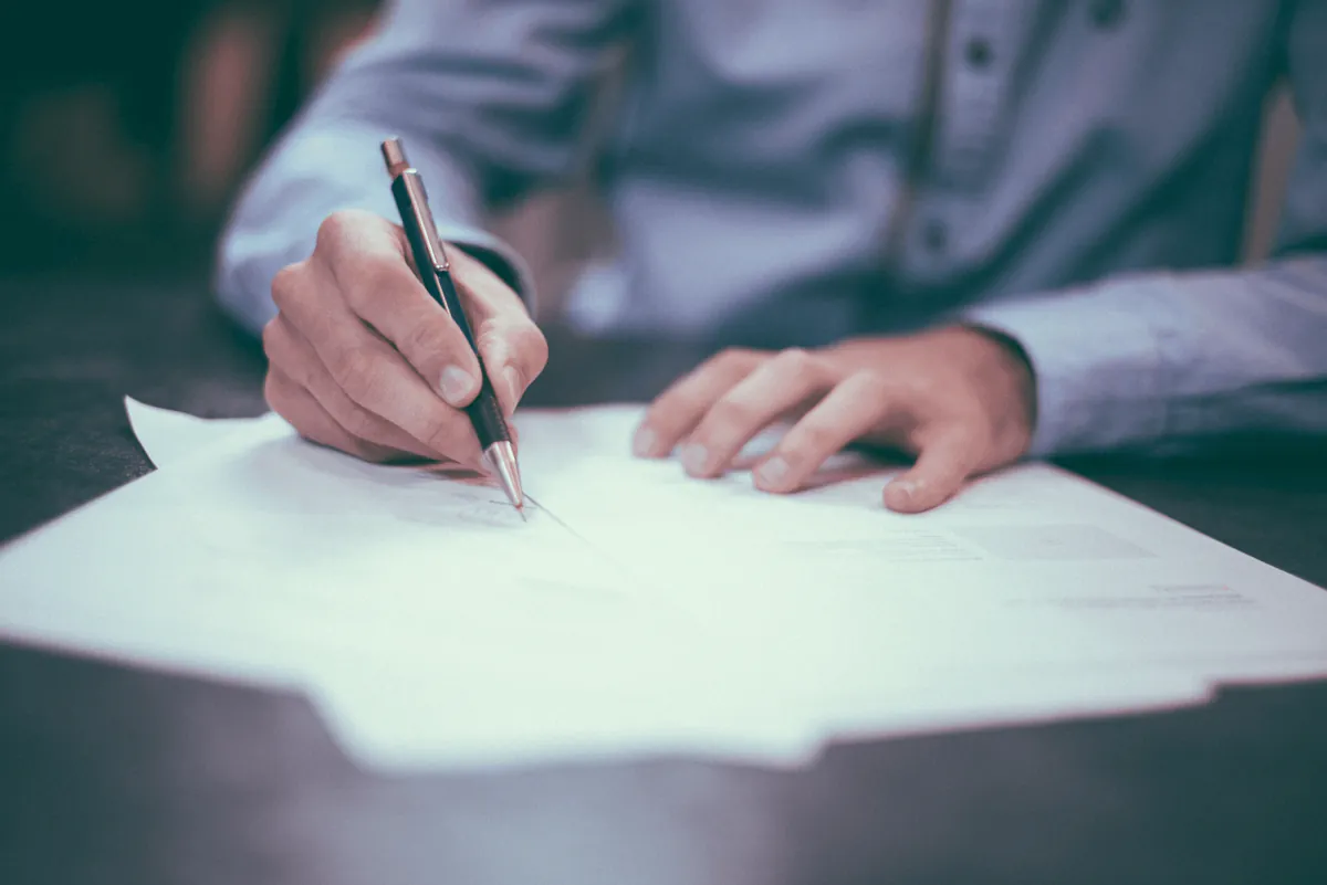 Business professional signing a document, representing the approval process of a quote or invoice in financial transactions.