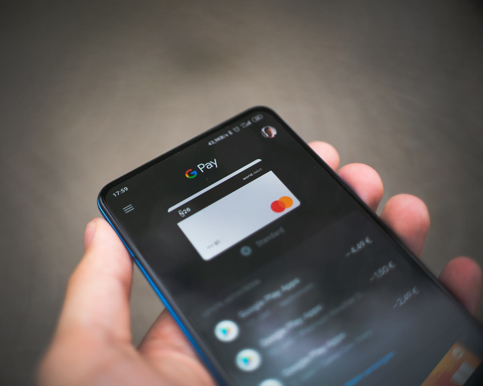 Close-up of a person holding a smartphone with a digital payment app open, displaying a virtual credit card. This illustrates the transition from invoice to payment, highlighting modern financial transactions and digital invoicing.
