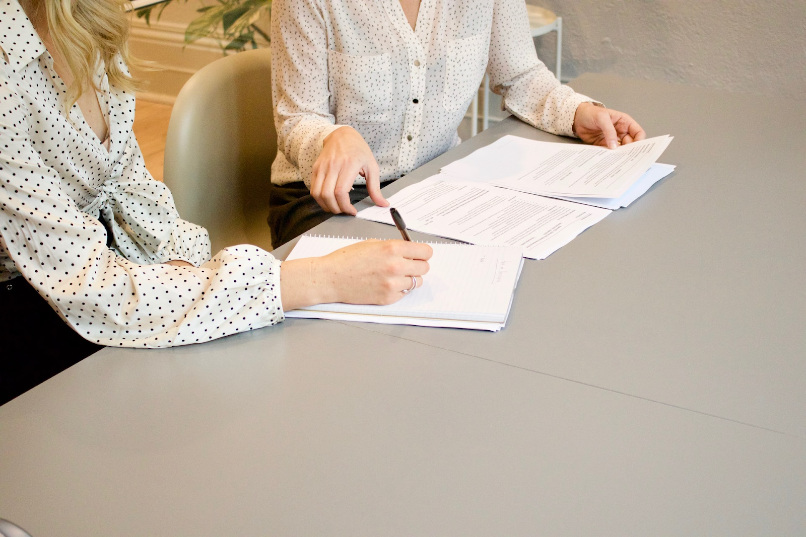 Two business professionals reviewing and discussing financial documents at a desk, representing the process of creating a quote versus issuing an invoice in business transactions.